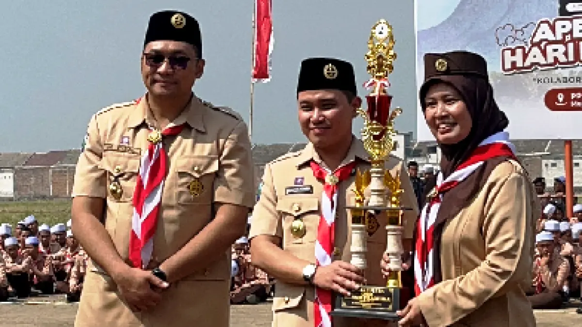 MELESAT: Bupati Muhammad Albarraa menyerahkan piala HUT Pramuka kepada Kepala SMPN 1 Bangsal Farida Hanim. (Oce JPRM)