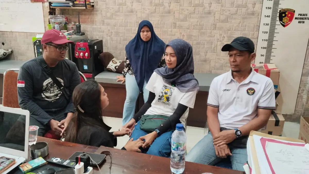 BERSIMPUH: Tersangka Inge Marita (baju hitam) bersimpuh di hadapan korban saat dilakukan mediasi di Mapolres Mojokerto Kota, Minggu (18/4). (Martda JPRM)