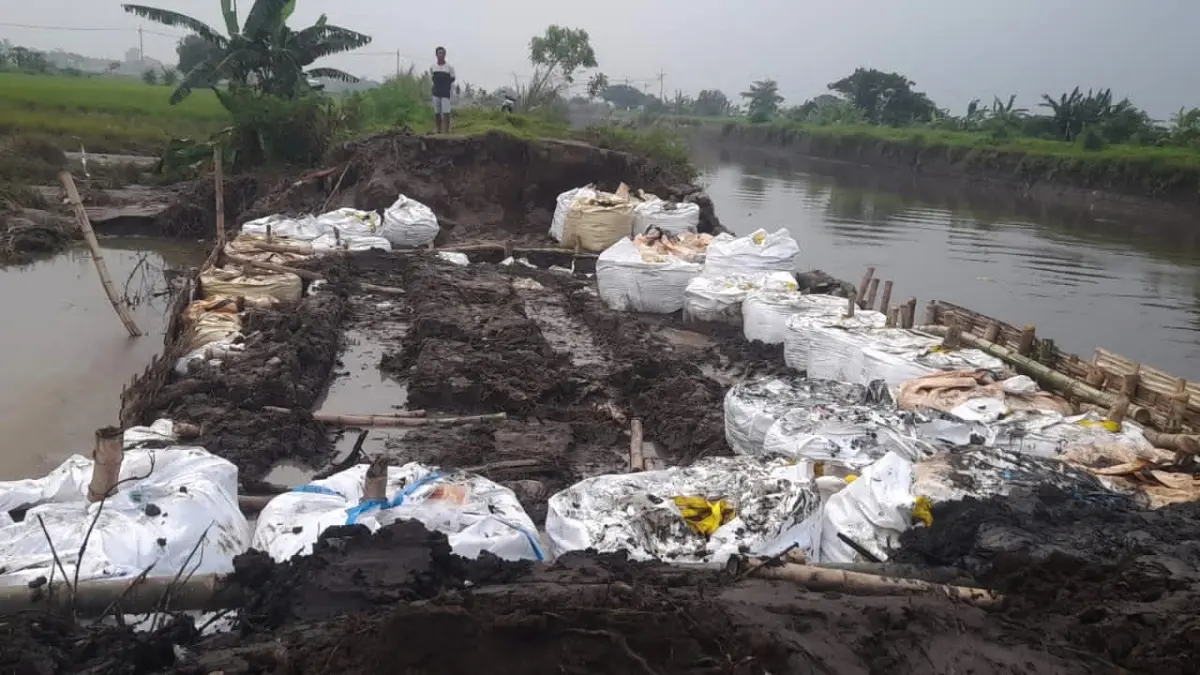 DITUTUP: Tanggul jebol di Sungai Sadar, Desa Jumeneng, Kecamatan Mojoanyar dilakukan penanganan darurat menggunakan alat berat dari tim DPUPR Kabupaten Mojokerto dan BBWS Brantas.&nbsp;(Rizal JPRM)
