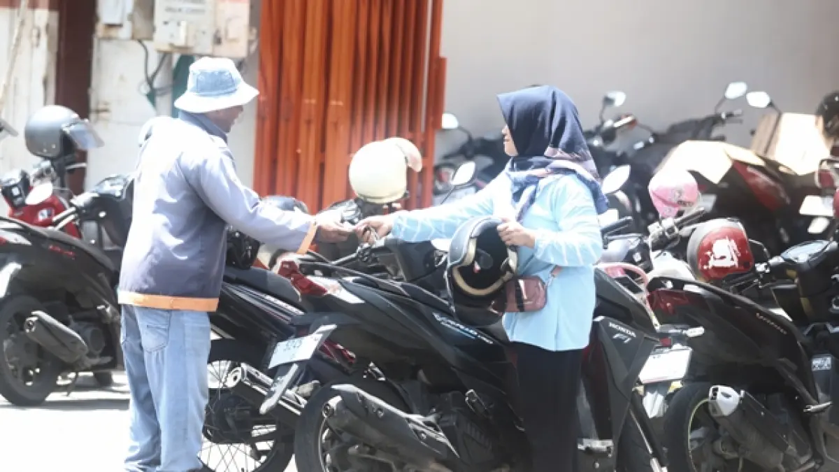 DISOROT: Warga membayar biaya parkir kepada juru parkir di area parkir berlangganan di Jalan Mojopahit, Kota Mojokerto, Minggu (5/4). (Sofan JPRM)