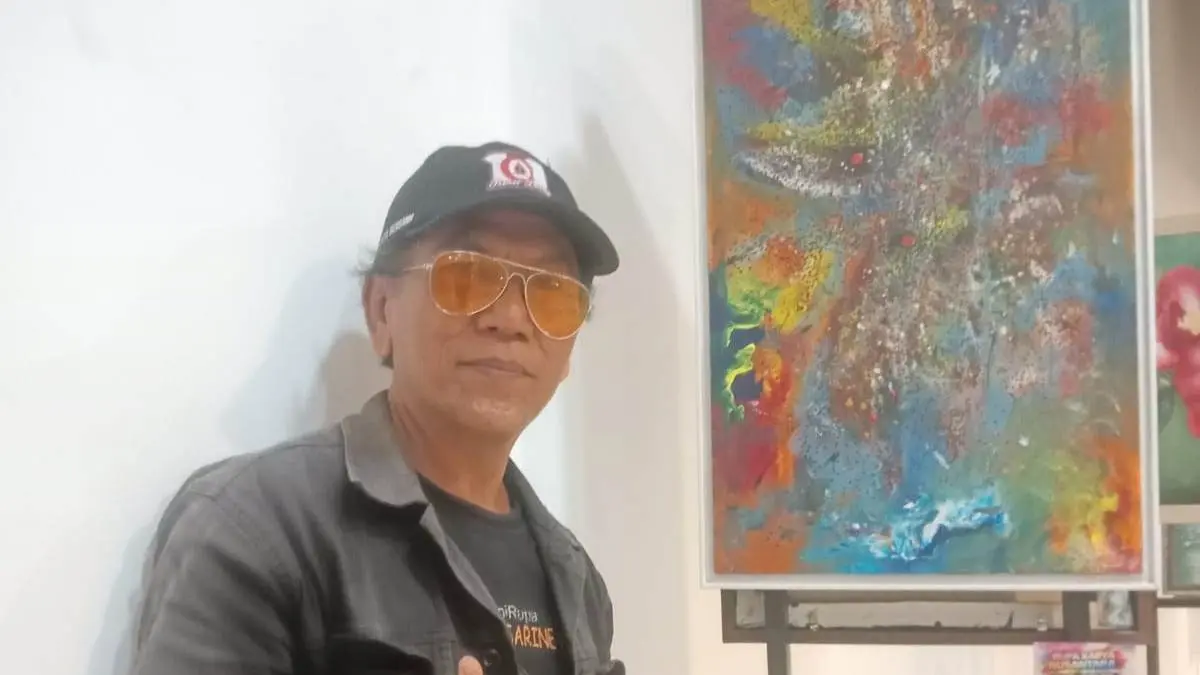 Priyok Dynasti, pelukis asal Kota Mojokerto bersama karyanya dalam pameran Karya Nusantara di Surabaya, Sabtu (25/4).