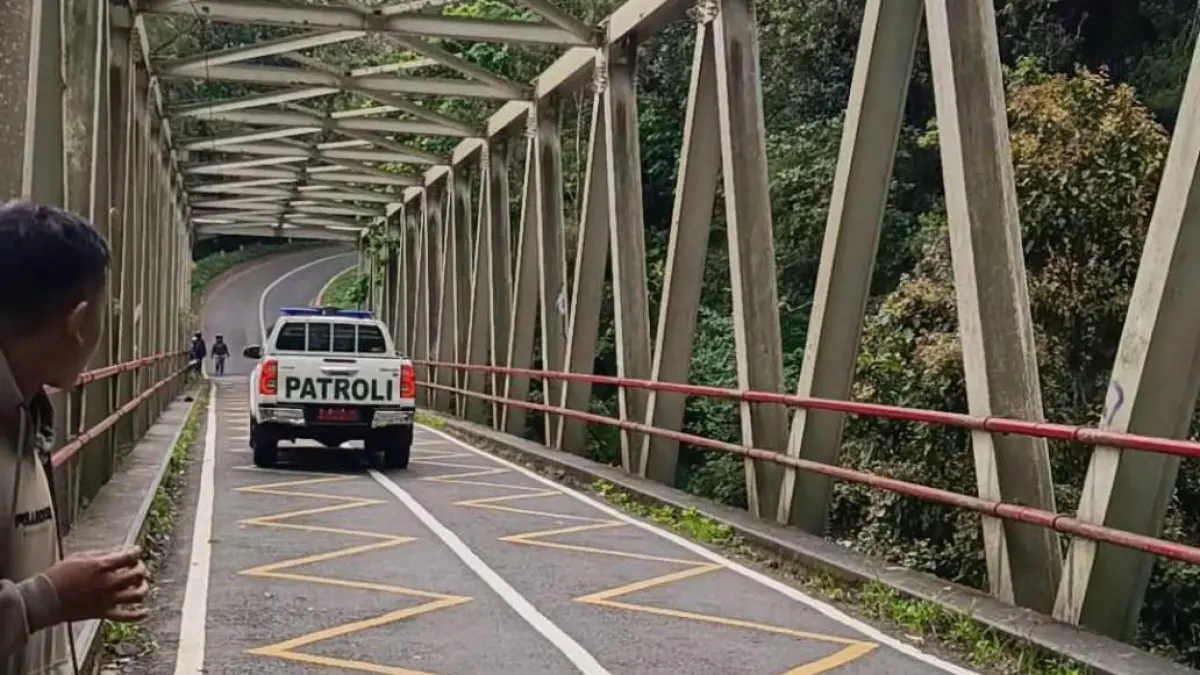 DIHALAU: Petugas Tahura Raden Soerjo mengimbau warga agar tidak berhenti di sepanjang jembatan yang menghubungkan jalur Cangar-Pacet.&nbsp;(Rizal JPRM)