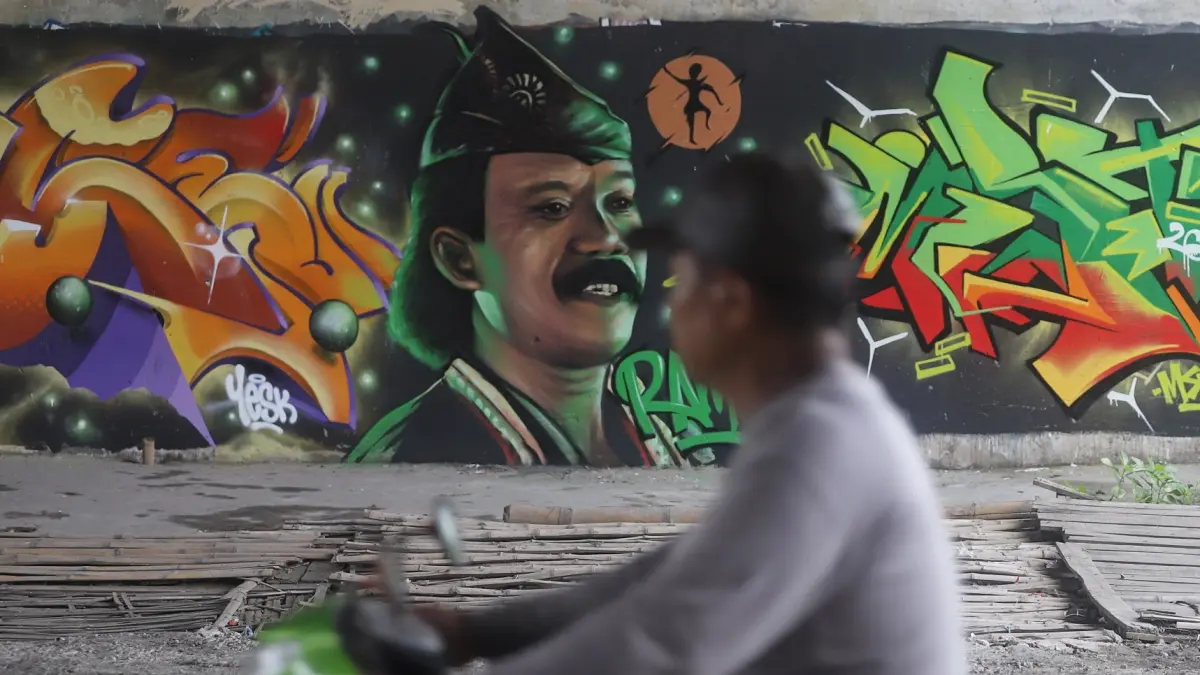 SENI JALANAN: Pengendara melintas di bawah jembatan tol Jombang-Mojokerto (Jomo), Desa Sidoharjo, Kecamatan Gedeg, Kabupaten Mojokerto, Senin (27/4). (Sofan JPRM)