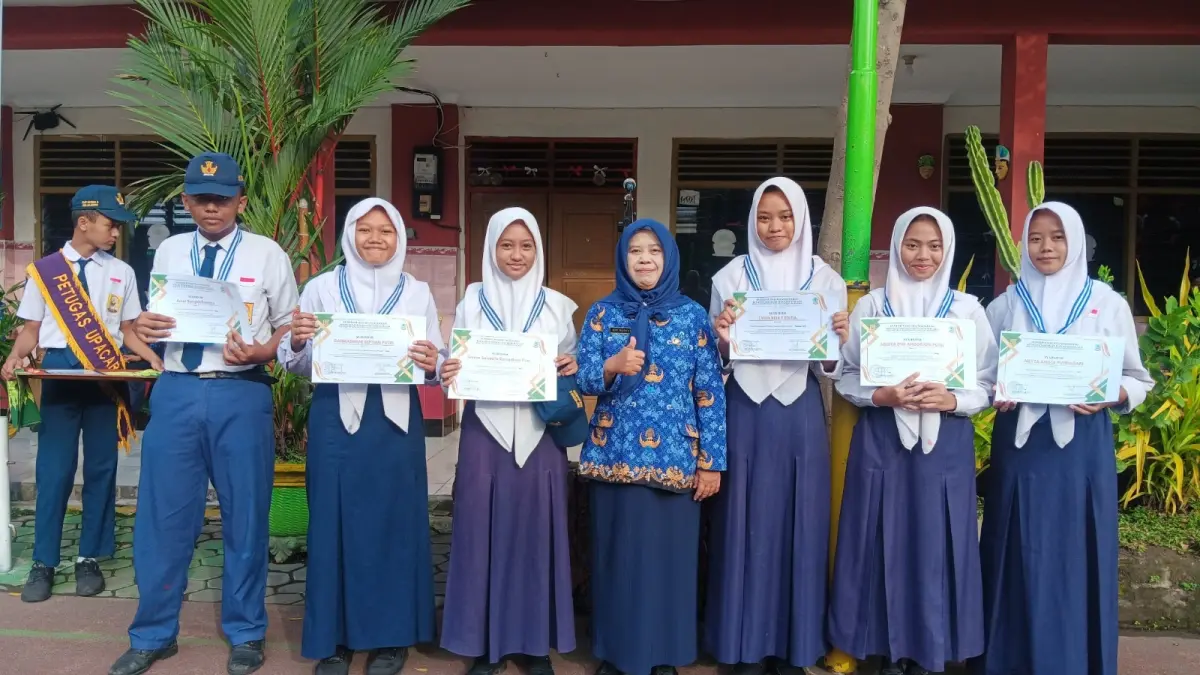 INOVATIF: Kepala SMPN 8 Mojokerto Siti Nuryati menyerahkan apresiasi atas raihan kejuaraan kepada siswa berprestasi. (Oce JPRM)
