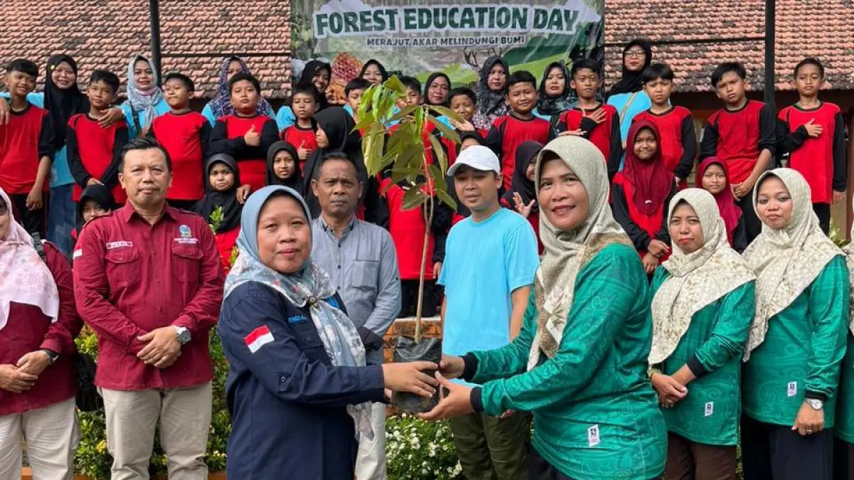 SIMBOLIS: Kepala Dinas Cabang Kehutanan Endah Setyawati menyerahkan bibit pohon kepada Kepala SDN Sumbergirang 1 Ririn Faridah dalam kegiatan Forest Education Day, kemarin (30/4). (Oce JPRM)