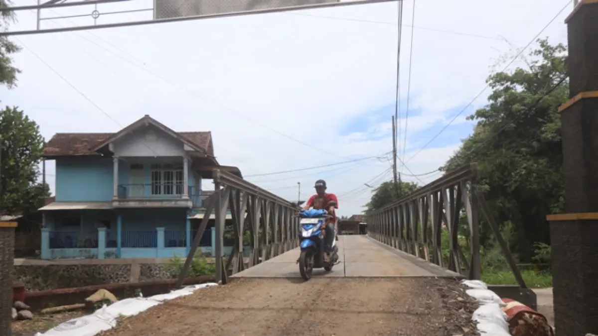 BERSIFAT SEMENTARA: Pengguna jalan melintasi jembatan bailey yang jadi akses darurat melewati Sungai Sumberkembar, Desa Wonodadi, Kecamatan Kutorejo, Kabupaten Mojokerto. (Sofan JPRM)