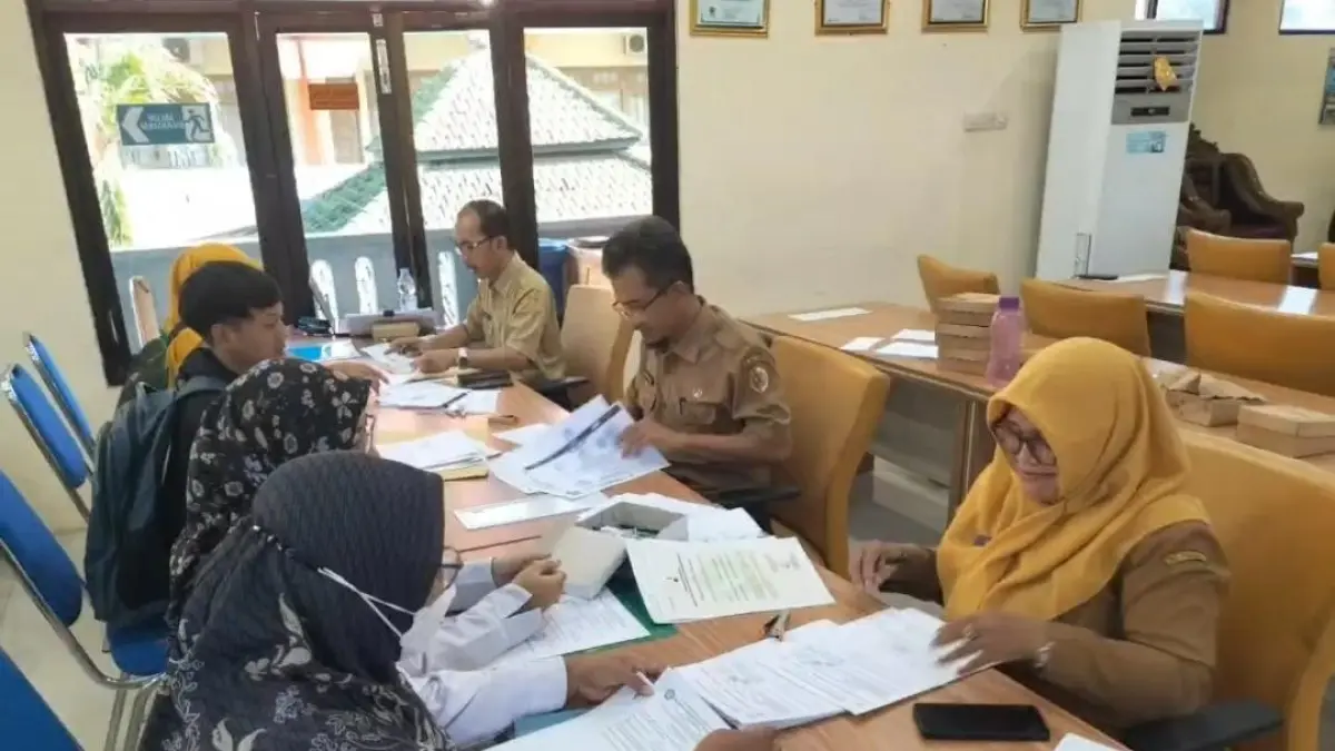 PENGECEKAN: Panitia SPMB Dispendik Kabupaten Mojokerto memeriksa dokumen yang menjadi syarat pendaftaran siswa baru dalam tahapan verval, kemarin (12/5). (Oce JPRM)