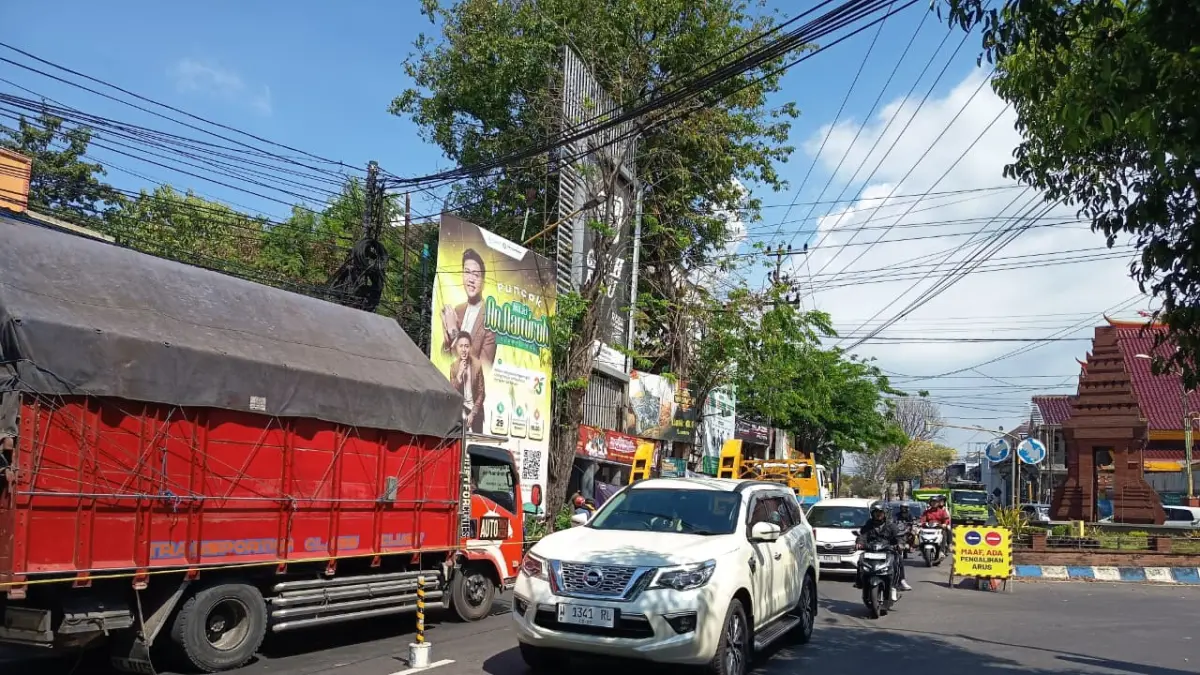 DIALIHKAN: Kendaraan yang melintasi simpang tiga Kelenteng Mojosari dilakukan pengalihan arus guna mengurai kemacetan panjang di masa libur panjang sampai akhir pekan ini.&nbsp; (Rizal JPRM)