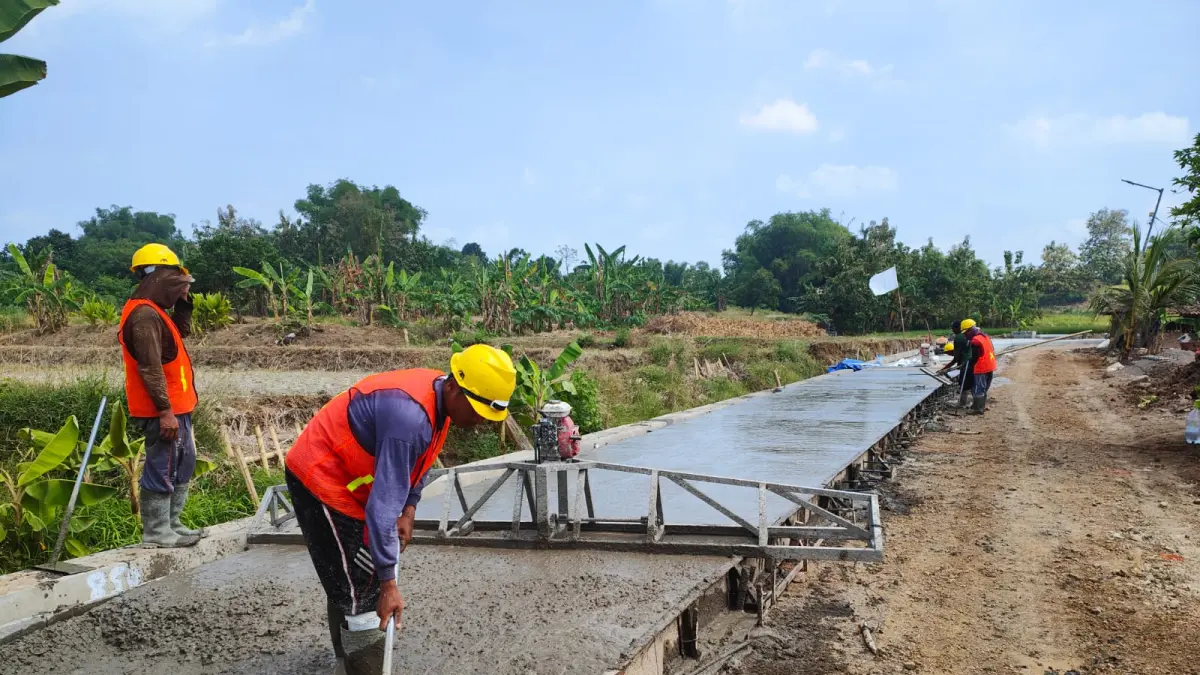 LAMPAUI TARGET: Para pekerja melakukan pengecoran pada ruas Jalan Lakardowo-Parengan, Kecamatan Jetis, yang ditetapkan sebagai proyek strategis daerah, kemarin (15/5). (Dori JPRM)