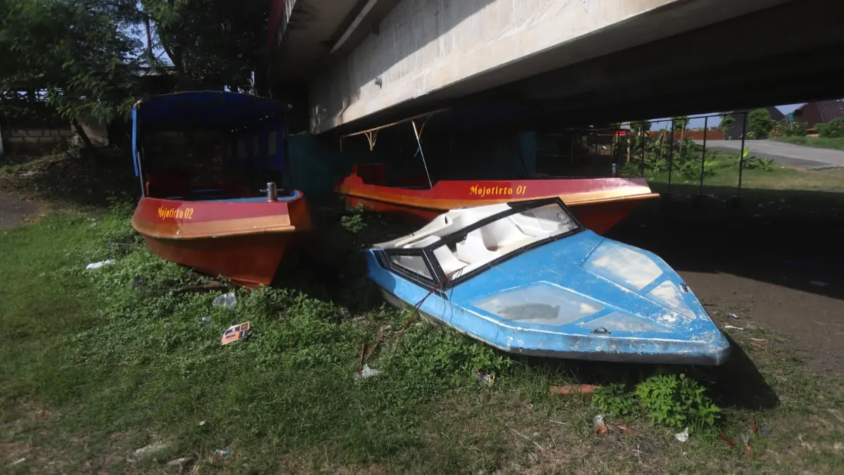 Tiga unit perahu wisata susur sungai terparkir di bawah Jembatan Rejoto, kawasan Taman Wisata Bahari Mojopahit, Kota Mojokerto.