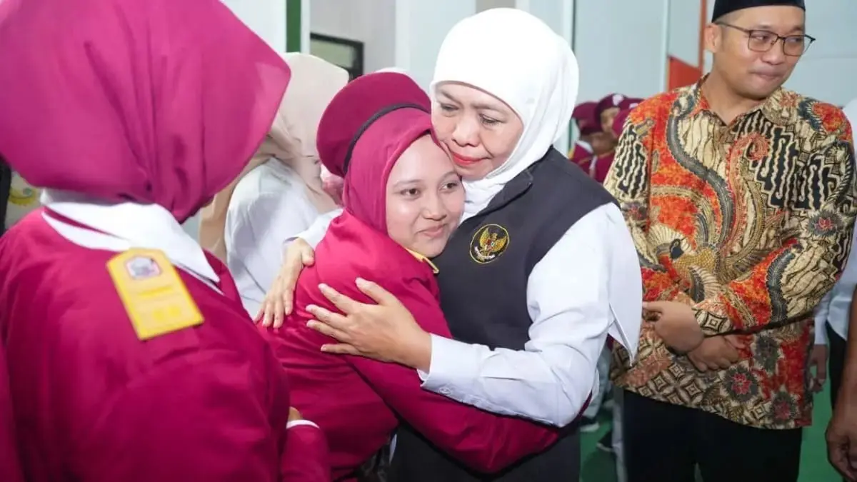 HANGAT: Gubernur Jatim Khofifah Indar Parawansa didampingi Wabup dr Muhammad Rizal Octavian memeluk siswa SRMP 15 Mojokerto saat peringatan Hardiknas, Sabtu (2/5) lalu. (dok JPRM)
