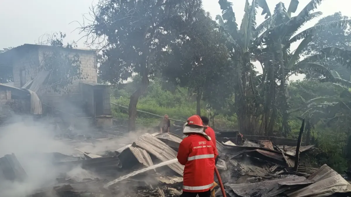 DIJINAKKAN: Tim Damkar BPBD Kabupaten Mojokerto memadamkan api yang meludeskan warung di Desa Awang-Awang, Kecamatan Mojosari, kemarin (19/5) pagi. 