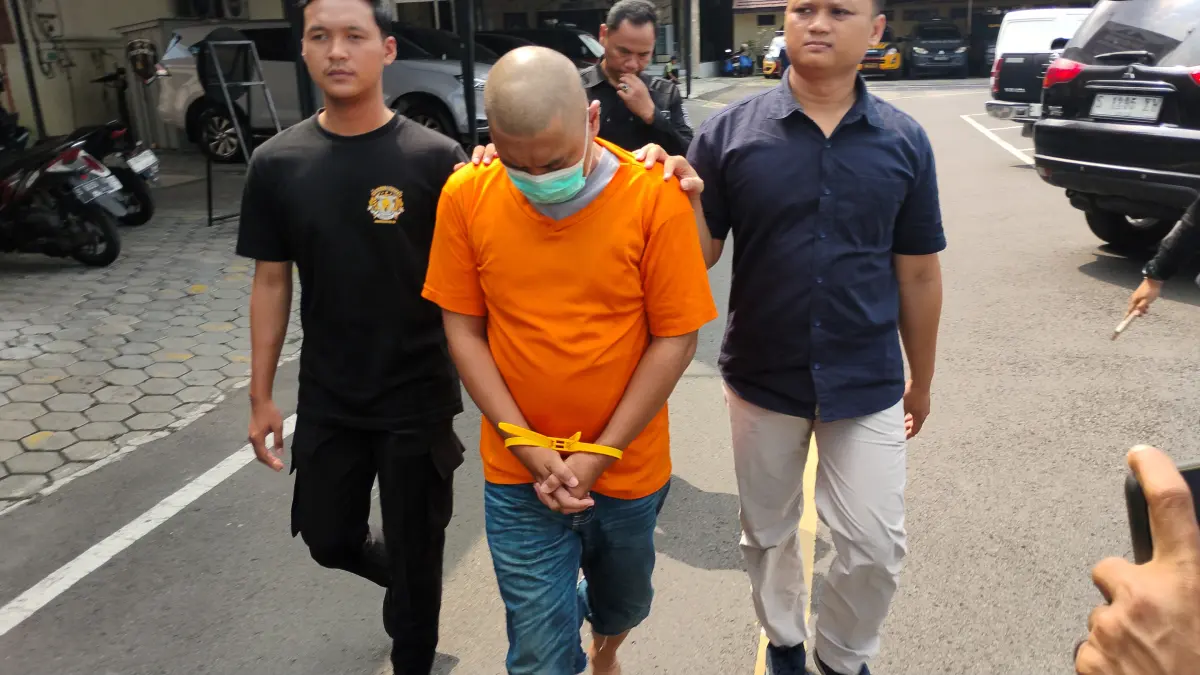 DIGELANDANG:&nbsp;IM dikeler petugas ke sel tahanan Polres Mojokerto Kota, kemarin (20/5). (Martda JPRM)