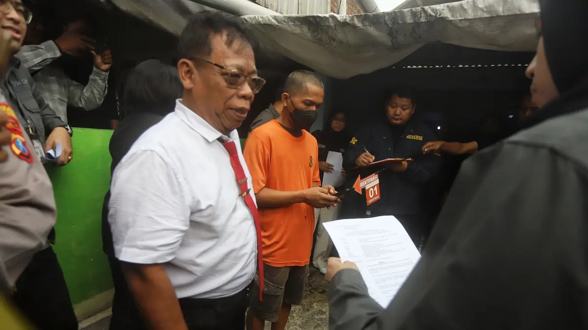 PENDAMPINGAN: Kuasa hukum tersangka, Kholil Askohar berbincang dengan jaksa Kejari Kabupaten Mojokerto di lokasi rekonstruksi kasus pembunuhan dan penganiayaan di Desa Sumbergirang, Kecamatan Puri, kemarin (22/5). (Sofan JPRM)