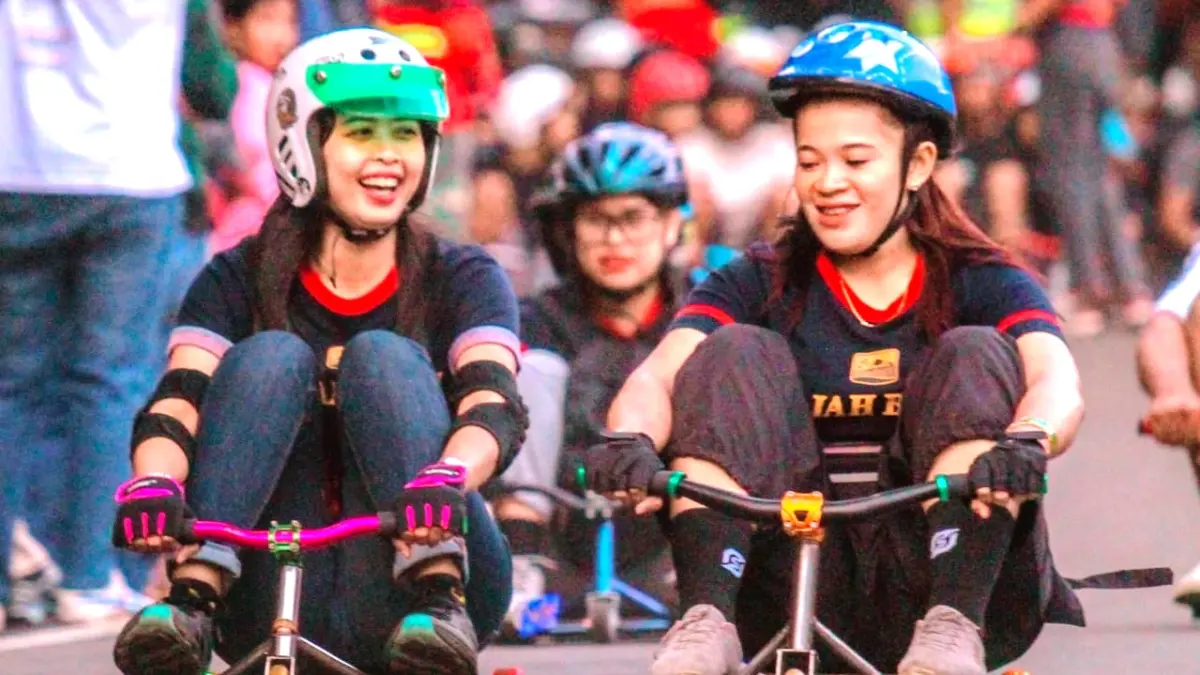 LAGI TREN: Dua cewek menaiki gledekan di jalanan menurun kawasan Pacet, Kabupaten Mojokerto, beberapa waktu lalu. Permainan ini tengah digandrungi anak-anak muda Mojokerto. (dok Eva Dia Sri Lestari for JPRM)
