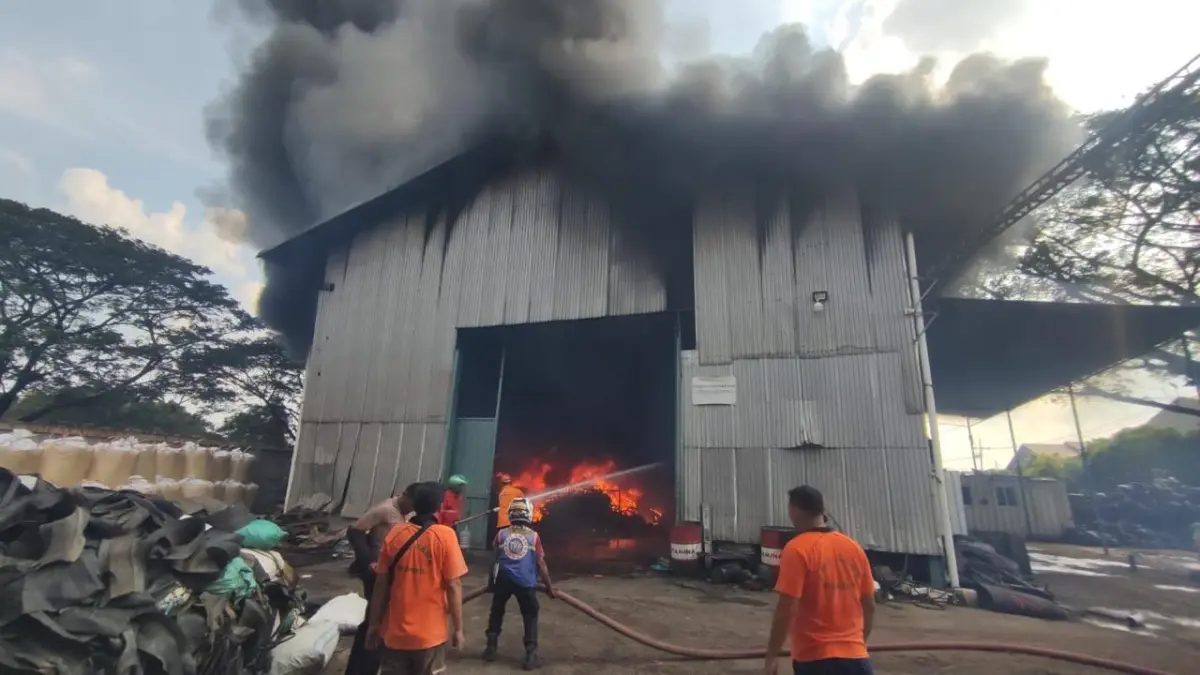 MENGEPUL: Petugas damkar dan relawan mencoba mengendalikan kebakaran gudang ban bekas di Kelurahan Gunung Gedangan, Kecamatan Magersari, Kota Mojokerto, kemarin (27/5). (Arief JPRM) 