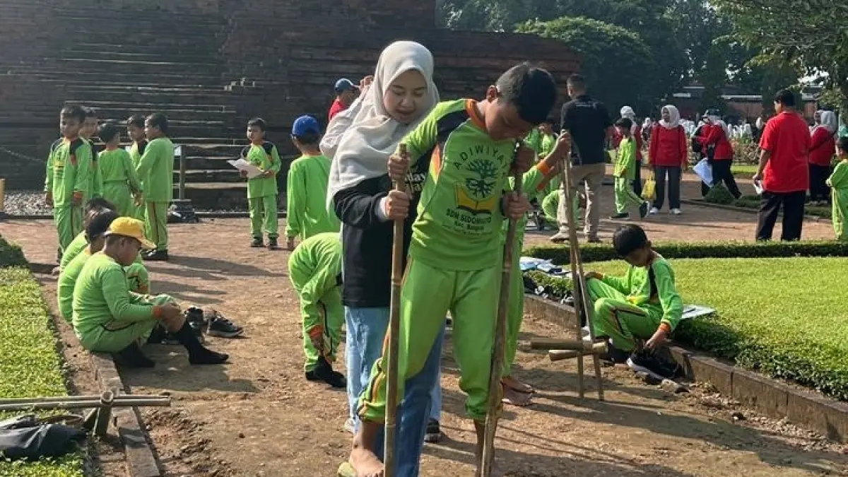 WAHANA TAMBAHAN: Para siswa dikenalkan permainan tradisional, seperti egrang dan bekiak raksasa pada pelaksanaan outing class di Kabupaten Mojokerto.