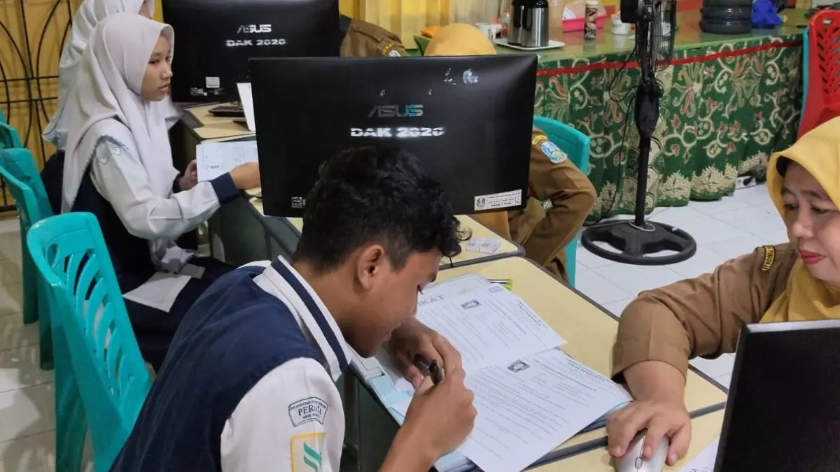 TAHAP VERVAL:&nbsp;Panitia SPMB SMP negeri dari Dispendik Kabupaten Mojokerto memeriksa dokumen persyaratan pendaftaran murid baru, Selasa (12/5). (Indah JPRM)