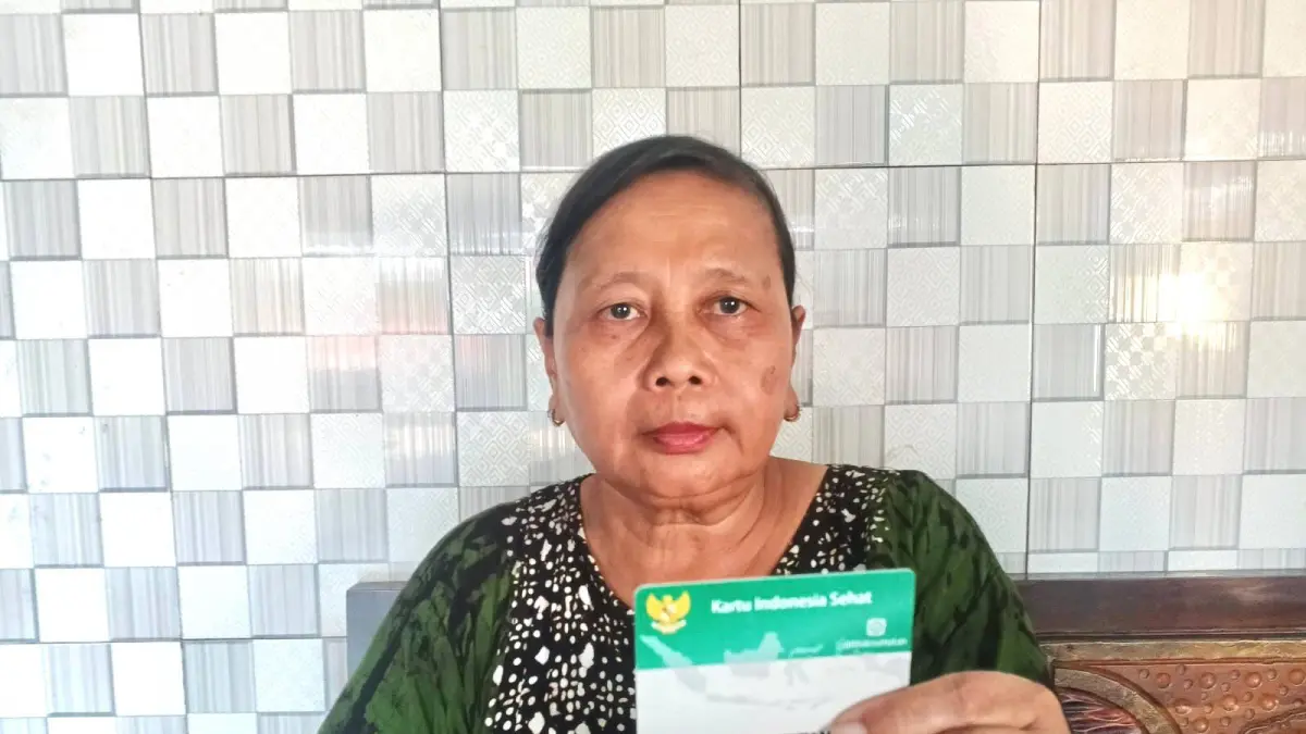 Eni Kustini (51), warga Kecamatan Bangsal, Kabupaten Mojokerto, yang terdaftar sebagai peserta BPJS Kesehatan segmen Penerima Bantuan Iuran Jaminan Kesehatan (PBI JK) yang iurannya ditanggung oleh pemerintah melalui Anggaran Pendapatan dan Belanja Negara (APBN). 