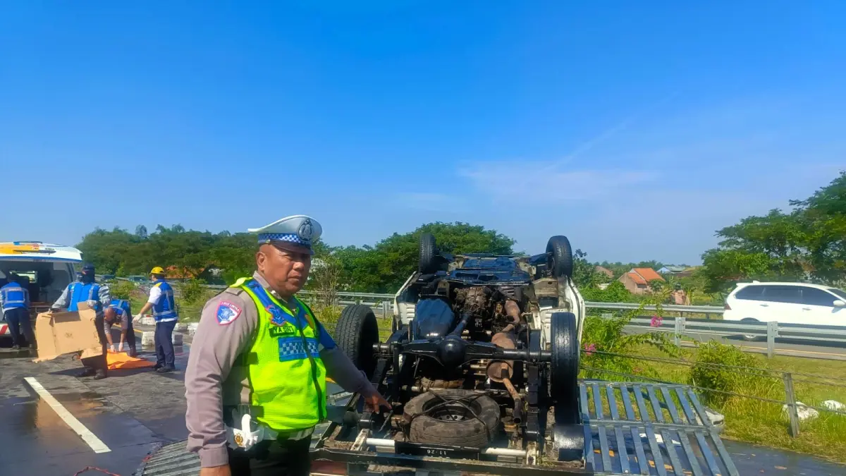 TERGULING:&nbsp;Petugas melakukan olah TKP insiden kecelakaan tunggal mobil pikap muatan minyak goreng di ruas Tol Sumo KM 717 + 600 A, Kamis (4/6). (dok PJR Ditlantas Polda Jatim for JPRM)
