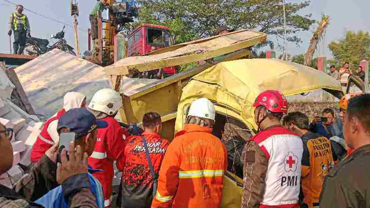 TERJEPIT: Petugas dan relawan berupaya mengevakuasi sopir truk muatan bata ringan yang nyungsep di By Pass area Dusun Genengan, Desa Banjar agung, Kecamatan Puri, Kabupaten Mojokerto, Selasa (9/6). (Fendy JPRM) 