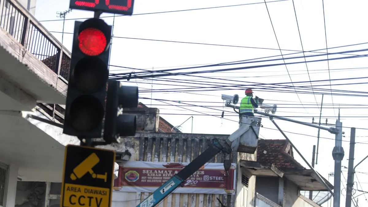 TILANG ELEKTRONIK: Petugas memeriksa kamera ETLE di simpang empat Jalan Majapahit, Kota Mojokerto. Perangkat tilang elektronik di wilayah hukum Polres Mojokerto Kota bakal ditambah hingga di Utara Brantas.