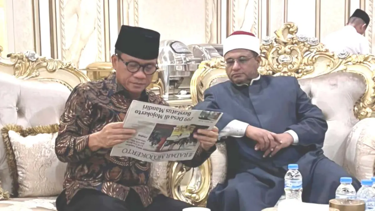 APRESIASI: Mendes PDT Yandri Susanto membaca rubrik Desakita di halaman Jawa Pos Radar Mojokerto di sela kunjungan ke Pondok Pesantren Amanatul Ummah, Desa Kembangbelor, Kecamatan Pacet, Minggu (14/6). (Imron JPRM)