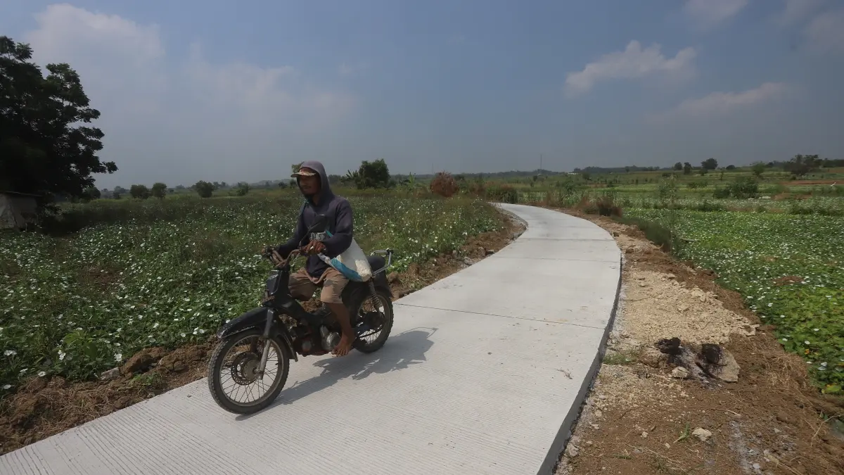 INFRASTRUKTUR MEMADAI: Petani melintas di jalan usaha tani (JUT) Desa Brayublandong, Kecamatan Dawarblandong, Kabupaten Mojokerto, Selasa (16/6). (Sofan JPRM)