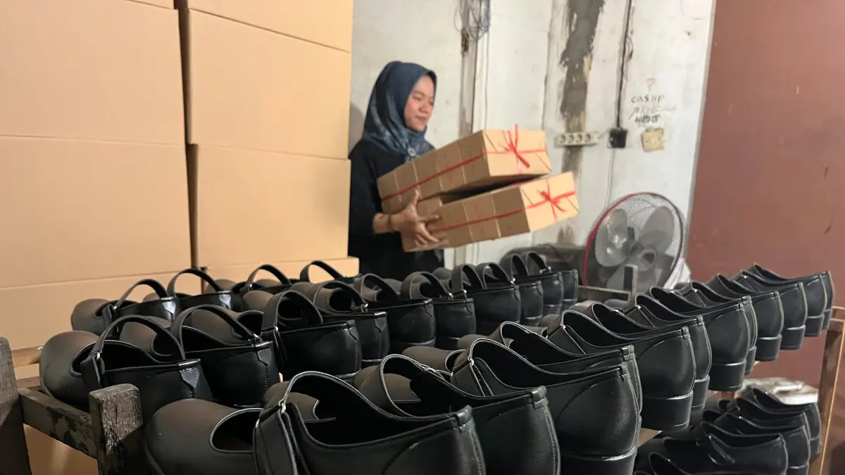 TETAP TERSENYUM: Mar’atus Sholikhah, membereskan produksi sepatunya sebelum diambil customer untuk dipasarkan ke siswa di tahun ajaran baru 2026-2027. (Farisma JPRM)