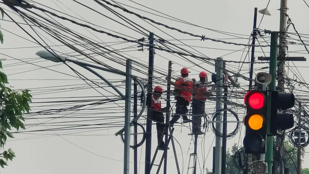 GANGGU ESTETIKA: Kondisi tiang dan kabel FO ilegal di perempatan Jalan RA Basuni, Desa/Kecamatan Sooko yang tampak semrawut pada 29 Januari lalu. Kondisi itu belakangan juga jadi sorotan BPK RI. (Dori JPRM)