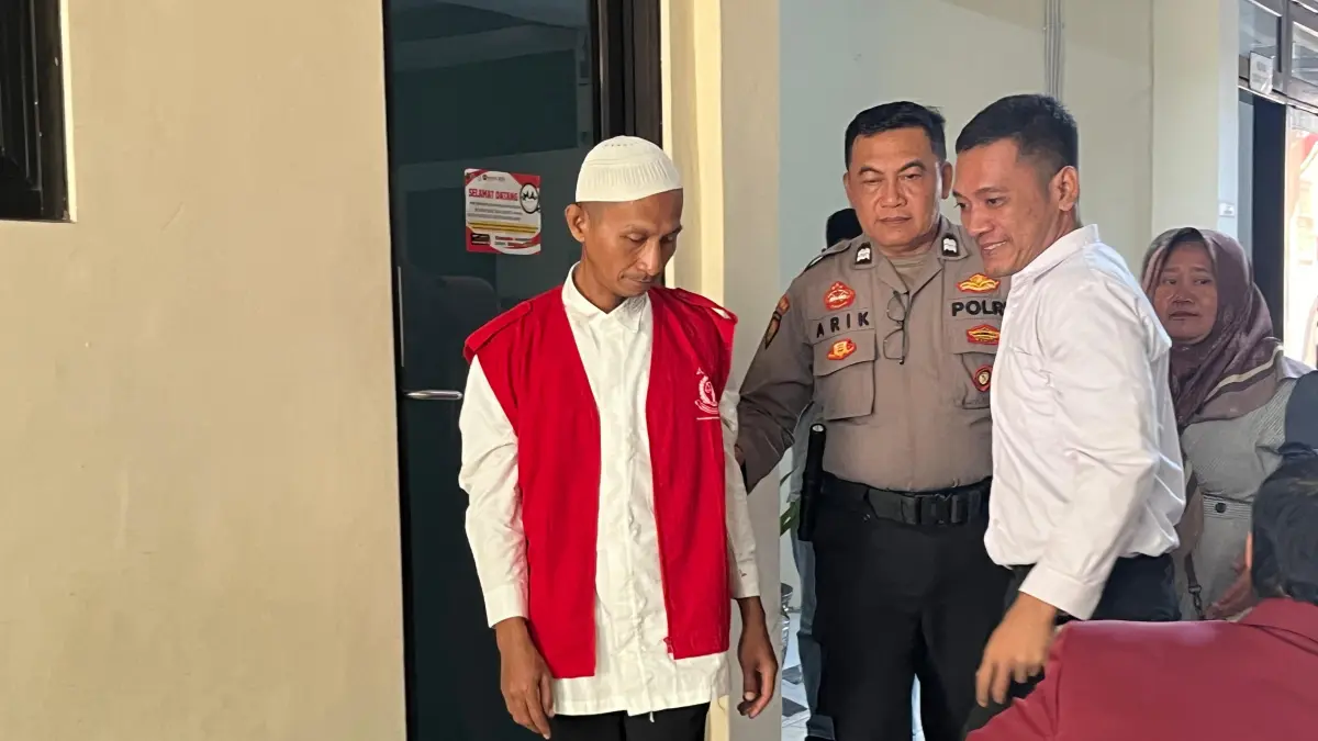 HARAP-HARAP CEMAS: MS, terdakwa kasus pornografi saat digelandang petugas kepolisian dari ruang sidang di Pengadilan Negeri Mojokerto kemarin (22/6). (Farisma JPRM)