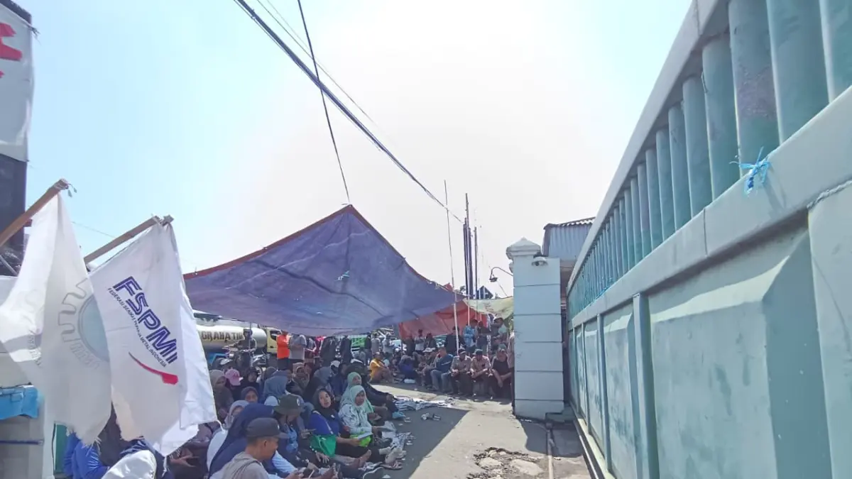 BERTAHAN: Para buruh PT Pakerin bertahan di bawah tenda di depan gerbang perusahaan untuk menggelar aksi menuntut pembayaran upah yang menunggak tiga bulan, kemarin (24/6). (Rizal JPRM)