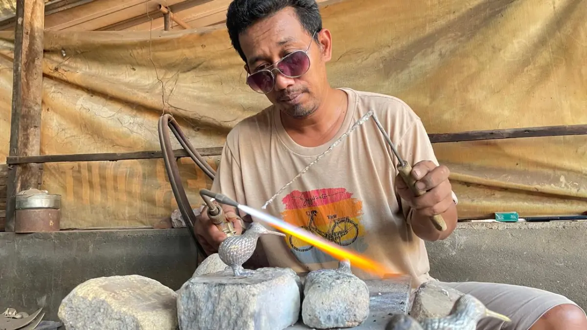 TERAMPIL: Perajin cor kuningan di Desa Bejijong, Kecamatan Trowulan, Kabupaten Mojokerto mengerjakan pesanan&nbsp;buyer, kemarin (24/6). (Cariris JPRM)