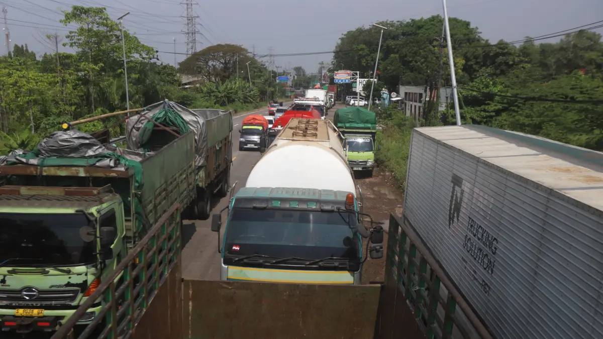TERPAKSA BERMALAM:&nbsp;Antrean truk angkutan barang rela menunggu pengiriman solar bersubsidi dari depo Pertamina di SPBU 54.613.01, Jalan Raya Bypass Mojokerto, Lingkungan Kuwung, Kelurahan Meri, Kecamatan Kranggan, kemarin (25/6). (Sofan JPRM)