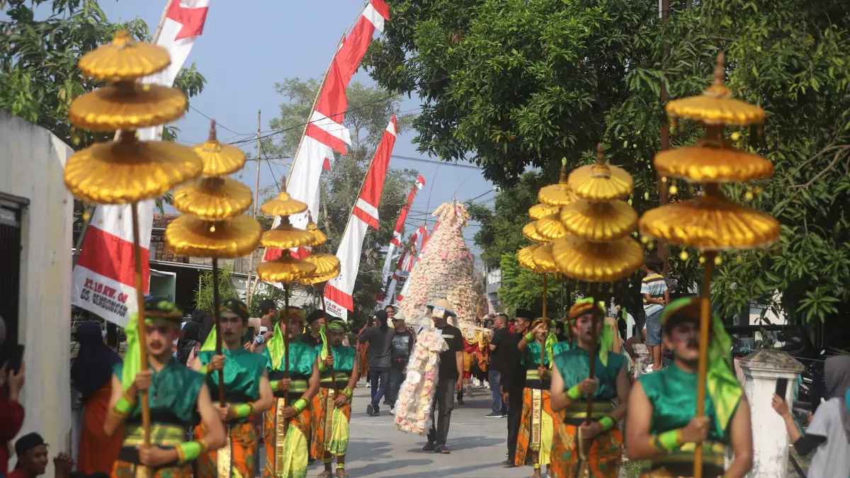 CUCUK LAMPAH: Dayang-dayang dari gadis dusun setempat menjadi cucuk lampah kirab alat dan hasil pertanian dalam kirab budaya sedekah bumi Desa Gembongan, Kecamatan Gedeg, Kabupaten Mojokerto, kemarin (27/6). (Sofan JPRM)