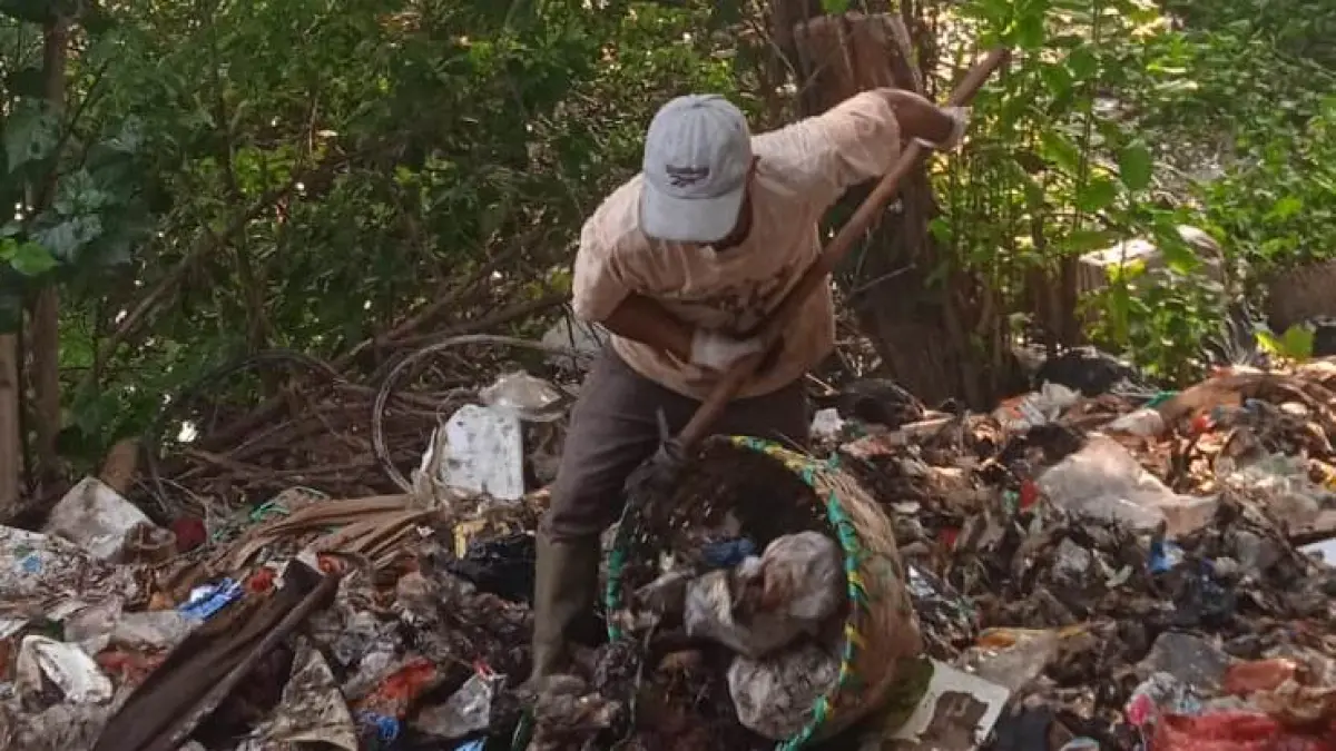 DIBERSIHKAN: Petugas DLH Kota Mojokerto membersihkan sampah yang menumpuk di Bantaran Sungai Brantas belakang TPS Hayam Wuruk, kemarin (27/6). (dok DLH Kota Mojokerto for JPRM)
