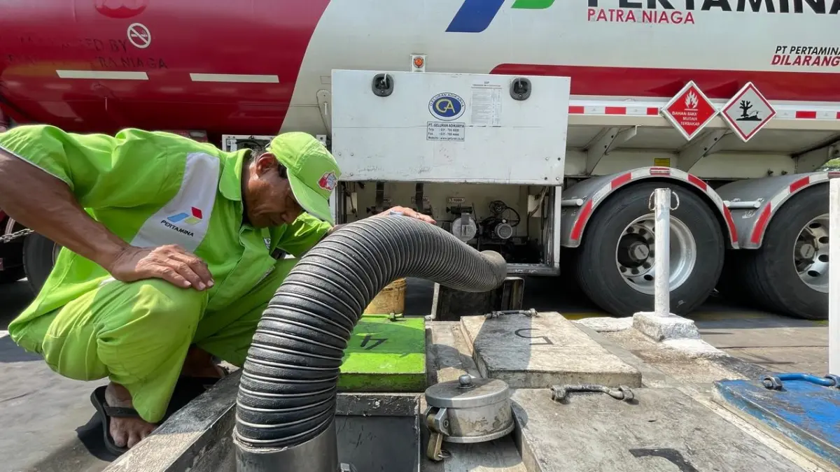 TERSENDAT: Petugas SPBU di Jalan Raya Bypass Kota Mojokerto, Lingkungan Kuwung, Kelurahan Meri, Kecamatan Kranggan mengecek proses pengisian tangki pendam BBM subsidi jenis solar yang baru dikirim dari depo Pertamina, Kamis (25/6). (Chariris JPRM)
