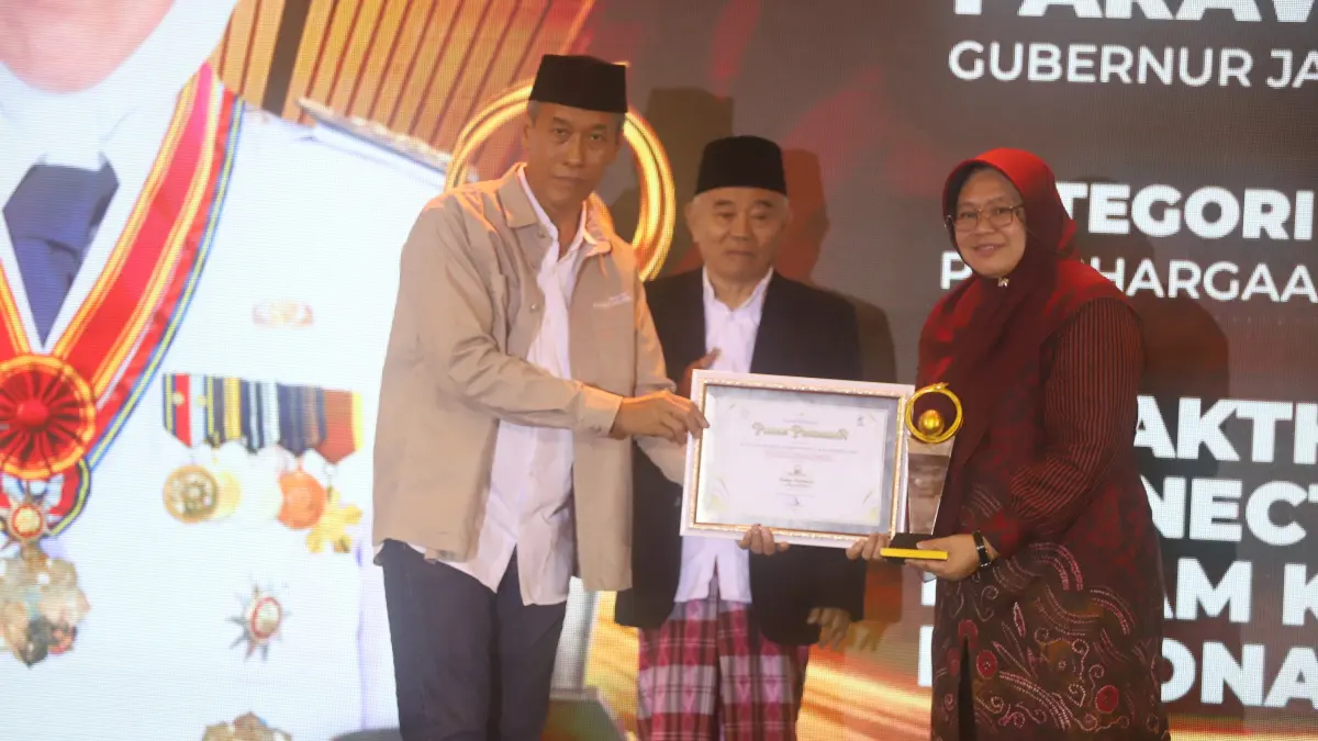 Direktur JPRM M. Nur Kholis menyerahkan penghargaan Radar Mojokerto Award 2026 kepada Gubernur Jawa Timur Khofifah Indar Parawansa yang diwakili oleh Kepala Dinas Komunikasi dan Informatika Jawa Timur Sherlita Ratna Dewi Agustin saat seremoni Radar Mojokerto Award 2026 di Sunrise Hotel, Kota Mojokerto, Selasa (7/7). (Sofan JPRM)