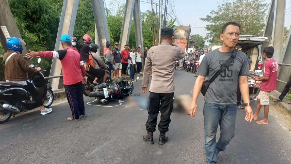 NAHAS: Aparat kepolisian dan petugas ambulans mengevakuasi pengendara motor yang tewas akibat kecelakaan di Jembatan Ngembeh, Desa/Kecamatan Dlanggu, Kabupaten Mojokerto, Selasa (7/7). (Rizal JPRM)