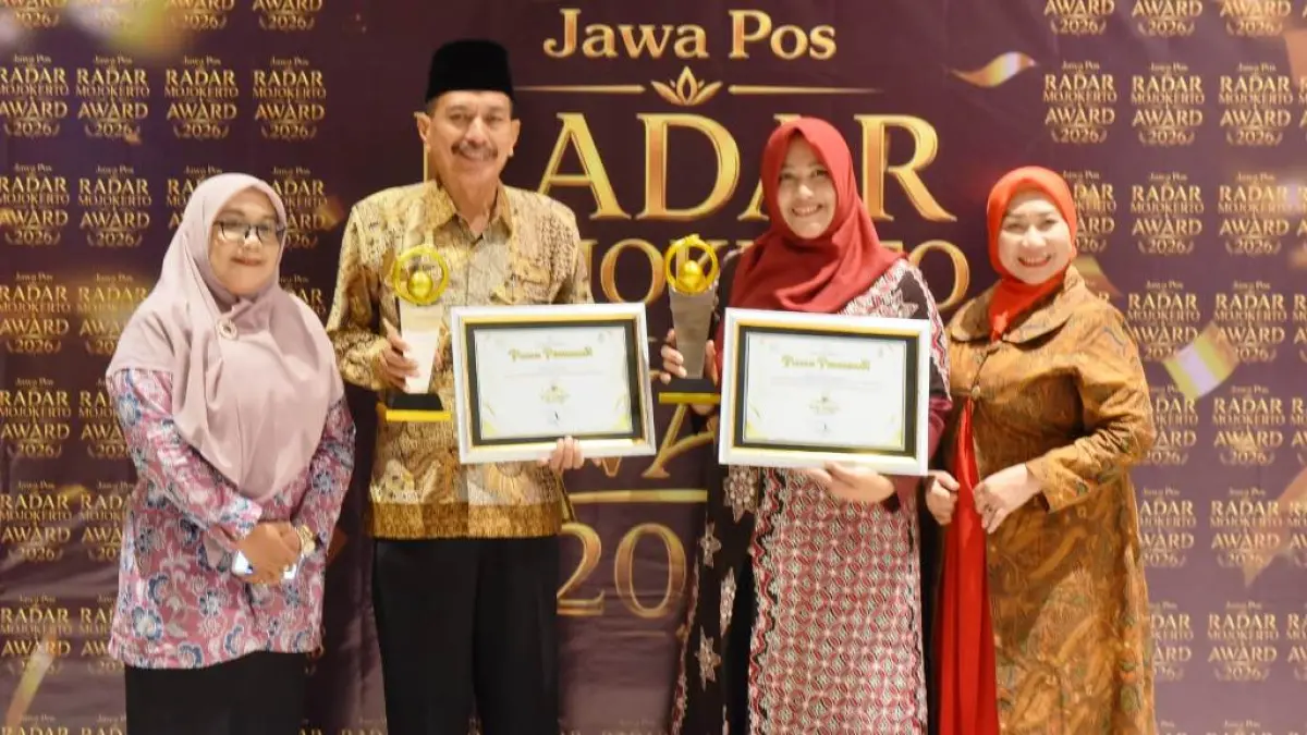 Kepala SMAN 1 Puri Kabupaten Mojokerto Sutoyo bersama Kepala Cabdindik Provinsi Jatim Wilayah Kabupaten dan Kota Mojokerto Pinky Hidayati sama-sama menerima penghargaaan Jawa Pos Radar Mojokerto Award yang digelar di Ballroom Sunrise Hotel Mojokerto, Senin (6/7). (Fendy JPRM)