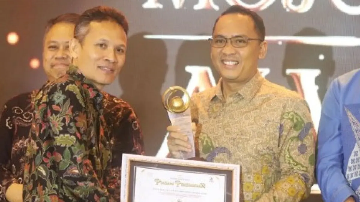 KOLABORASI DAN KOMUNIKASI: Kepala Bagian Materi dan Komunikasi Pimpinan Zainal Muttaqin mewakili Kepala Biro Administrasi Pimpinan Setdaprov Jatim Pulung Chausar menerima penghargaan Jawa Pos Radar Mojokerto Award 2026 kategori The Collaborative and Inclusive Communication for Community Empowerment, yang diserahkan langsung Direktur Jawa Pos Radar (JPR) Marsudi Nurwahid, di Ballroom Sunrise Hotel Mojokerto, Selasa (7/7) malam. (Sofan JPRM)