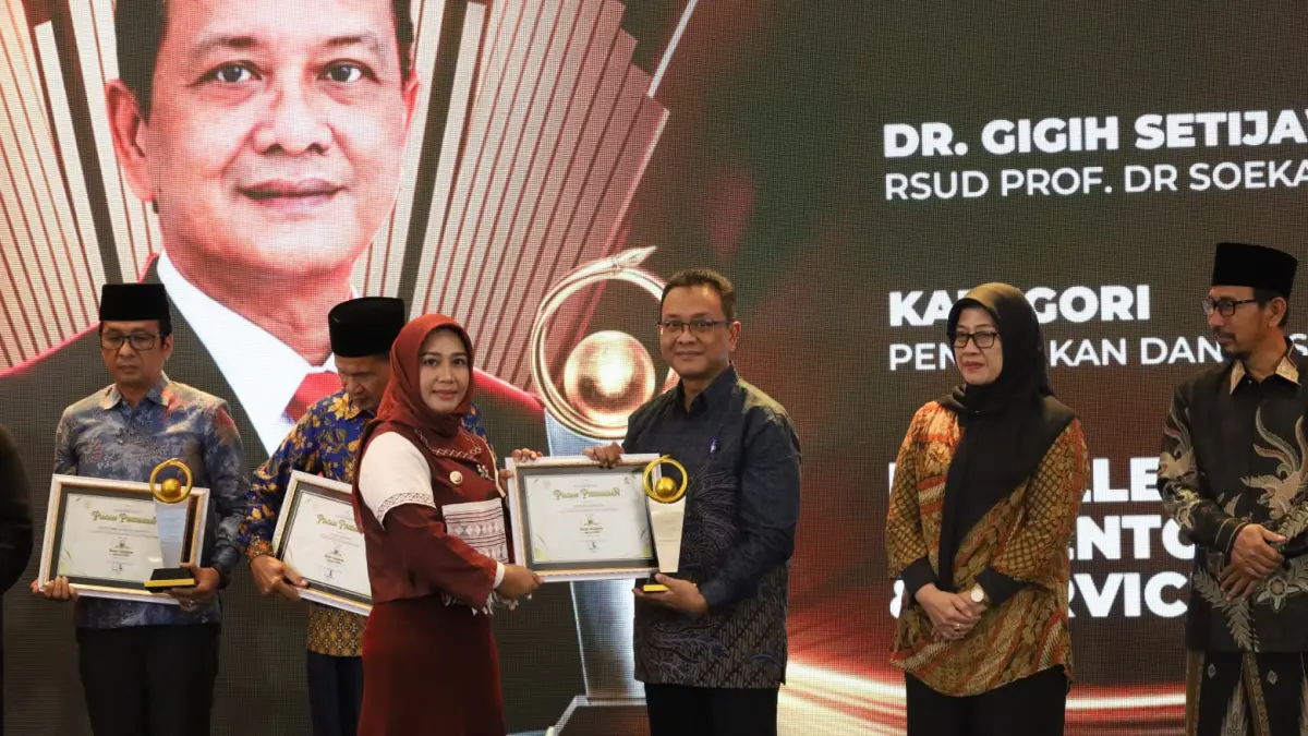 Plt Direktur RSUD Prof Dr Soekandar dr Gigih Setijawan, Sp.P, MARS, FISR menerima penghargaan Jawa Pos Radar Mojokerto Award 2026 yang diberikan oleh Wali Kota Mojokerto Ika Puspitasari saat malam penghargaan yang digelar di Ballroom Sunrise Hotel Mojokerto, Kota Mojokerto, pada Selasa (7/7) lalu. (Sofan JPRM)