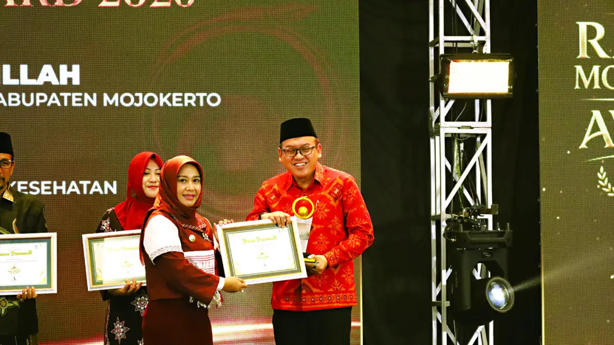 Kepala BPKAD Kabupaten Mojokerto Iwan Abdillah menerima penghargaan Jawa Pos Radar Award 2026 yang diserahkan Wali Kota Mojokerto Ika Puspitasari dalam malam penghargaan yang digelar di Ballroom Sunrise Hotel Mojokerto, Kota Mojokerto pada Senin (7/7). (Sofan JPRM)