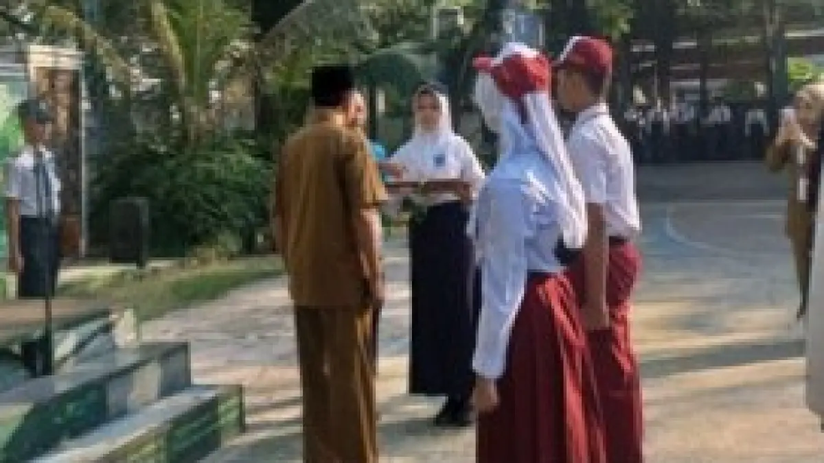 PENGENALAN SEKOLAH: Kepala SMPN 1 Mojosari Subai menyambut calon peserta didik baru tahun ajaran 2026/2027 di halaman sekolah, Senin (13/7). Pada hari pertama sekolah, siswa langsung mengikuti kegiatan MPLS untuk tanamkan nilai dasar dan kedisiplinan. (Basuni JPRM)