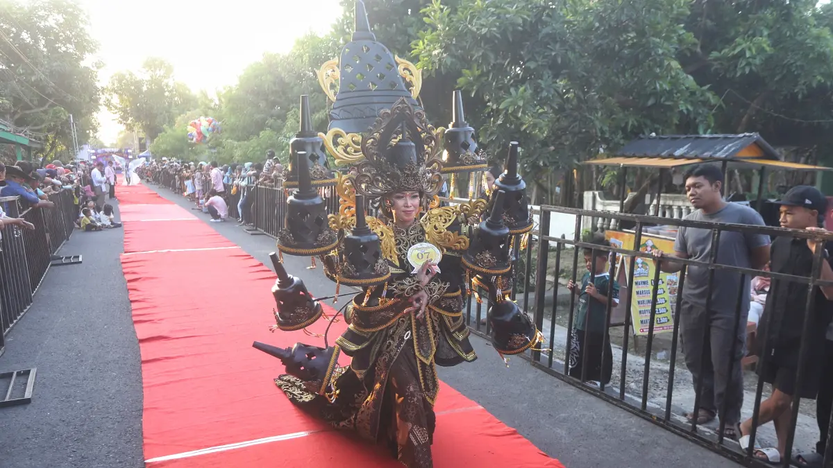 MERIAH: Peserta Ngingas Mojo Carvinal 2026 di Desa Ngingasrembyong, Kecamatan Sooko, Kabupaten Mojokerto menampilkan busana rancangannya, Minggu (12/7). (Sofan JPRM)

&nbsp;