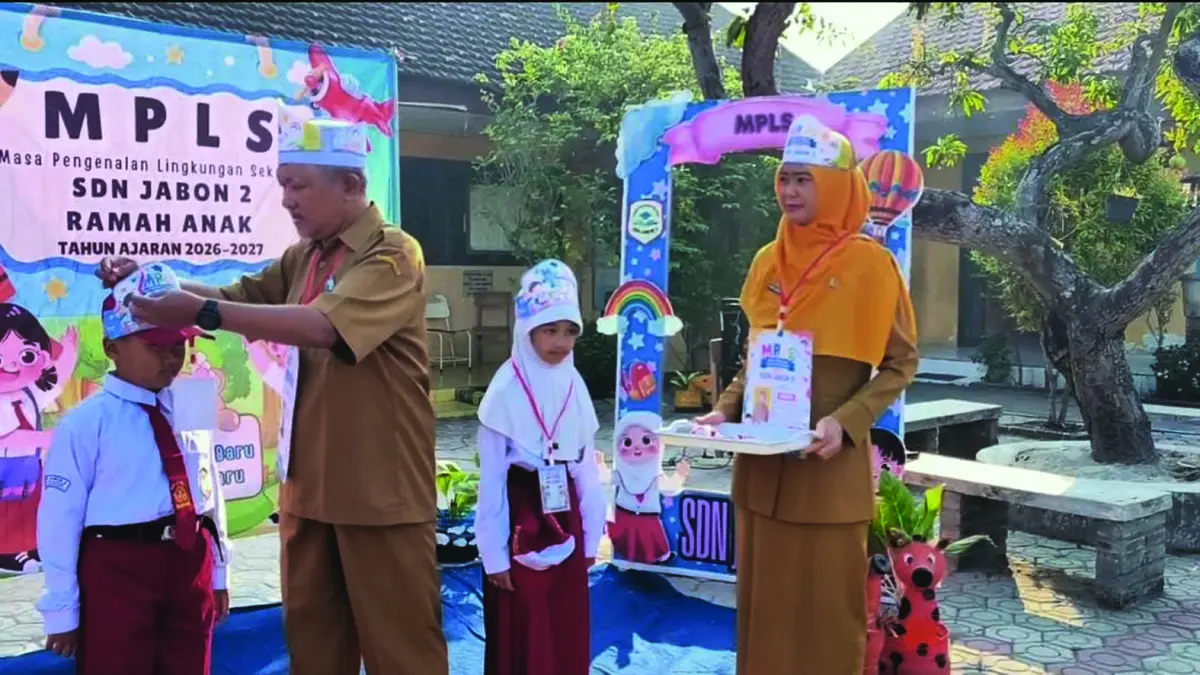 RESMI DIMULAI: Kepala SDN Jabon 2 Nurul Cholidi secara simbolis menyematkan tanda peserta MPLS kepada siswa baru, Senin (13/7). (Indah JPRM) 