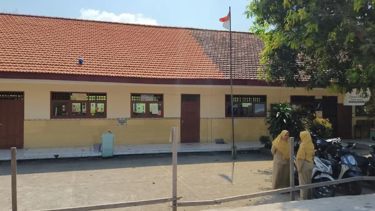 TANPA SAMBUTAN: Dua tenaga pendidik di SDN Pandankrajan 1, Kecamatan Kemlagi beraktivitas seperti biasa dari hari pertama masuk sekolah tahun ajaran baru 2026/2027, Senin (13/7). Lembaga pendidikan negeri tersebut diwacanakan bakal dimerger setelah tidak mendapat satupun murid baru. (Indah JPRM)