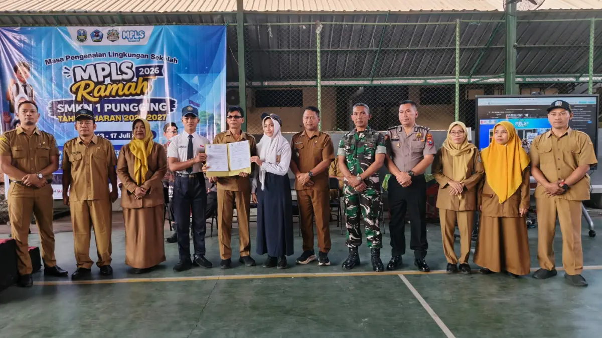 INTEGRITAS: Kepala SMKN 1 Pungging Muharto dan perwakilan siswa baru saat penyerahan dokumen komitmen pada pembukaan MPLS Ramah 2026, Senin (13/7). (Indah JPRM)