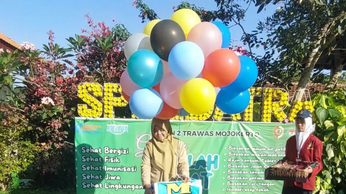 PEMBUKAAN: Kepala SMPN 2 Trawas Sri Winarni melepas balon dan menyematkan tanda peserta MPLS 2026 yang berlangsung hingga 17 Juli mendatang. (Martda JPRM)