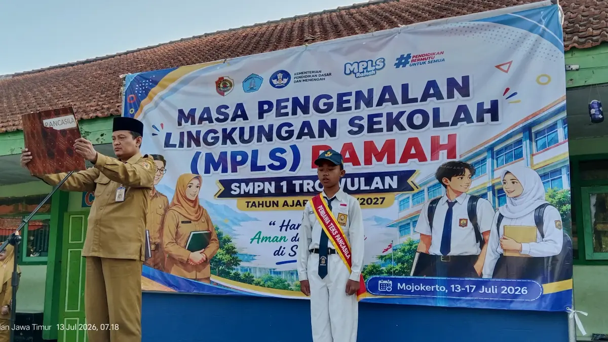 HARI PERTAMA: Kepala SMPN 1 Trowulan Hari Widarto memimpin pembacaan teks Pancasila saat pembukaan MPLS Ramah tahun ajaran 2026/2027 di halaman sekolah. (indah jprm)